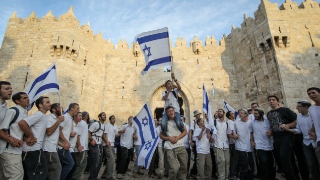 آلاف اليهودي يلوحون بالأعلام الإسرائيلية  خلال الإحتفال ب"يوم القدس" من خلال المرور في شوارع القدس، عبر  باب العامود في طريقهم إلى الحائظ الغربي في 20 مارس، 2012.  (Nati Shohat/Flash90)