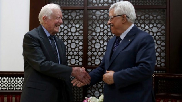 رئيس السلطة الفلسطينية محمود عباس يصافح الرئيس الأمريكي السابق جيمي كارتر خلال لقائهما في 2 مايو، 2015 في مدينة رام الله بالضفة الغربية. (AFP/Pool/Abbas Momani)