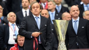 رئيس الإتحاد الأوروبي لكرة القدم ميشيل بلاتيني (من اليسار) يقف إلى جانب كأس الدوري الأوربي لكرة القدم في وارسو، بولندا في 27 مايو، 2015. (AFP/Piotr Hawale)