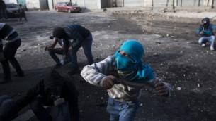 شباب فلسطينيون يرشقون الحجارة خلال مواجهات مع شرطة الحدود الإسرائيلية في مخيم شعفاط في القدس الشرقية، 7 نوفمبر 2014 (Yonatan Sindel/Flash90)