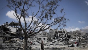فلسطينيون يبحثون عن ممتلكاتهم بين الطام بعد غارة اسرائيلية في بيت لاهيا، شمال قطاع غزة، 4 اغسطس 2014 (Emad Nasser/Flash90)