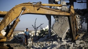 رجل فلسطيني يمتطي حصانه عبر أنقاض المياني، التي دٌمرت خلال الحرب الأخيرة بين إسرائيل وحماس والتي استمرت ل50 يوما في صيف 2014، في مدينة غزة، 21 يوليو، 2015 (AFP PHOTO / MOHAMMED ABED)