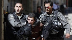 قوات الأمن الإسرائيلية تعتقل رجل فلسطيني خلال اشتباكات بين متظاهرين فلسطينيين والشرطة الإسرائيلية في البلدة القديمة في القدس، 26 يوليو 2015 (AFP PHOTO / AHMAD GHARABLI)