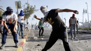 صورة توضيحية: شبان فلسطينيون يلقون الحجارة على الشرطة الإسرائيلية خلال مواجهات في القدس الشرقية، 4 يوليو، 2014. (Sliman Khader/Flash90)