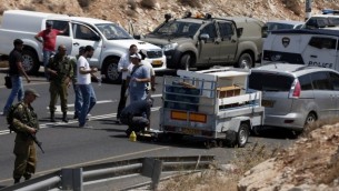 صورة توضيحية للشرطة تتفحص موقع هجوم اطلاق نار استهدف مركبة اسرائيلية في طريق بالقرب من مستوطنة كوخاف هاشاحار في الضفة الغربية، 31 يوليو 2015 (AFP PHOTO/THOMAS COEX)