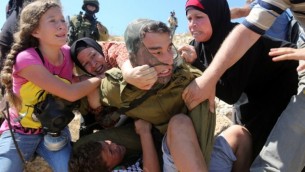 فلسطينيات يحاولن عرقلة محاولة جندي اسرائيلي لاعتقال طفل فلسطيني في بلدة النبي صالح في الضفة الغربية، 28 اغسطس 2015 (AFP Photo/Abbas Momani)