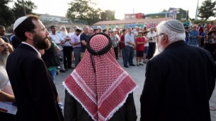 الشيخ إبراهيم أحمد أيو الحوا (الوسط)، مع الحاخام يعكوف ناغن (من اليسار) والحاخام بينجامين كالمانزون ، كلاهما من معهد "أونتييل" الديني، إلى جانب عدد آخر من الحاخامات، خلال صلاة إحتجاجية من أجل أسرة دوابشة في تقاطع طرق غوش عتصيون، 2 أغسطس، 2015. (Nati Shohat/Flash90)