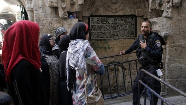 نساء فلسطينيات من حركة "المرابطات" يدحدثن مع شرطي اسرائيلي يمنعهن من الوصول الى الحرم القدسي خلال مظاهرة ضد زيارة اليهود الى الحرم، 20 سبتمبر 2015 (AFP PHOTO / AHMAD GHARABLI)