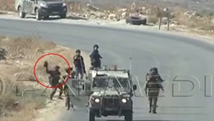 صورة التقطت من شريط فيديو في الضفة الغربية يظهر جندي اسرائيلي يرمي ما يبدو انها كاميرا تابعة لصحفيين في وكالة فرانس برس، 25 سبتمبر 2015 (screen capture: YouTube)