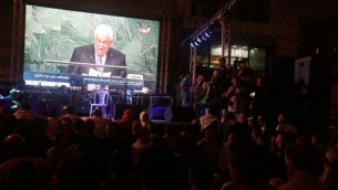 فلسطينيون يتابعون خطاب رئيس السلطة الفلسطينية محمود عباس على شاشة عملاقة في رام الله خلال الكلمة التي ألقاها أمام الجمعية العامة للأمم المتحدة في مقر المنظمة في نيويورك، 30 سبتمبر، 2015. (AFP/Jaafar Ashtiyeh)