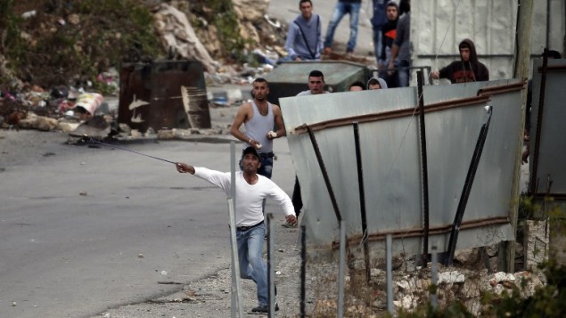 متظاهرون فلسطينيون يرشقون الحجارة باتجاه جنود اسرائيليين في مدخل بلدة بيت عنون بالقرب من الخليل، 26 اكتوبر 2015 (AFP/ THOMAS COEX) متظاهرون فلسطينيون يرشقون الحجارة باتجاه جنود اسرائيليين في مدخل بلدة بيت عنون بالقرب من الخليل، 26 اكتوبر 2015 (AFP/ THOMAS COEX)