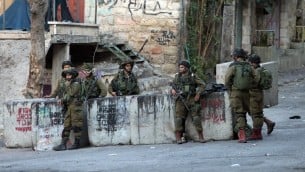 جنود اسرائيليون يحرسون بالقرب من مكان وقوع محاولة طعن جندي قبل اطلاق النار على المعتدي الفلسطيني وقتله في مدينة الخليل، 28 اكتوبر 2015 (AFP Photo/Hazem Bader)
