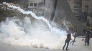 محتجون فلسطينيون يفرون من الغاز المسيل للدموع خلال مواجهات مع الشرطة بعد تظاهرة في مدينة رام الله بالضفة الغربية، 5 أكتوبر، 2015. (Photo by Flash90)