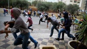 محتجون فلسطيينون يلقون الحجارة باتجاه القوات الإسرائيلية (لا تظهر بالصورة) خلال إحتجاجات بالقرب من مستوطنة بيت إيل، بالقرب من مدينة رام الله في الضفة الغربية، 10 أكتوبر، 2015. (Flash90)