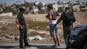 عناصر من شرطة حرس الحدود يفتشون سائقا فلسطينيا عند خروجه من حي جبل المكبر في القدس الشرقية، 14 أكتوبر، 2015. (Hadas Parush/Flash90)