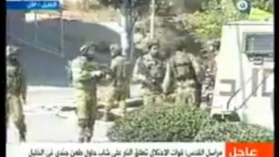 رجل فلسطيني تظاهر بأنه صحافي قام بطعن جندي إسرائيل، ما أدى إلى إصابته بجراح متوسطة قبل إطلاق النار على منفذ الهجوم من قبل القوات الإسرائيلية بالقرب من مدينة الخليل، 16 أكتوبر، 2015. (لقطة شاشة: قناة القدس)