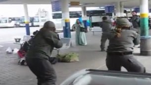 صورة شاشة لتصوير التقط بواسطة هاتف ذكي يظهر قوات الامن تحيط امرأة عربية من اسرائيل تحمل سكين بعد ان ورد انها حاولت طعن حارس في محطة الحافلات المركزية في العفولة، 9 اكتوبر 2015 (screen capture)