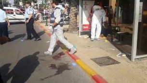 محققون من الشرطة في موقع هجوم الطعن في رعنانا، 13 أكتوبر، 2015. (لقطة شاشة: الشرطة الإسرائيلية)
