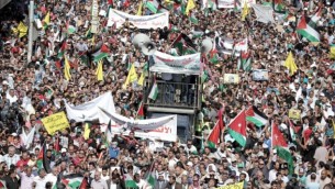 متظاهرون أردنيون يلوحون بالأعلام الأردنية والفلسطينية خلال مظاهرة بالقرب من السفارة الأردنية في العاصمة عمان تضامنا مع الفلسطينيي، 16 أكتوبر، 2015. (Khalil Mazraawi/AFP)