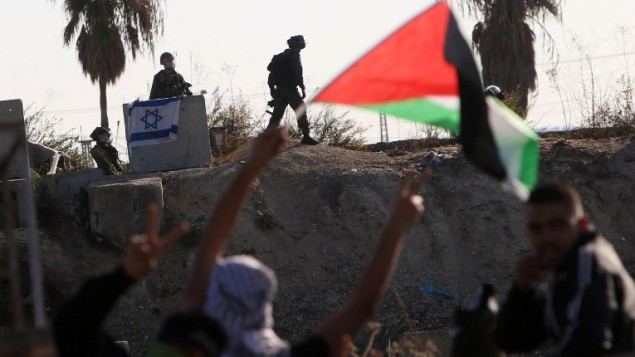 محتجون فلسطينيون يلوحون بالأعلام الفلسطينية خلال مواجهات مع القوات الإسرائيلية في مدينة طولكرم بالضفة الغربية، 12 نوفمبر، 2015. (Jaafar Ashtiyeh/AFP) محتجون فلسطينيون يلوحون بالأعلام الفلسطينية خلال مواجهات مع القوات الإسرائيلية في مدينة طولكرم بالضفة الغربية، 12 نوفمبر، 2015. (Jaafar Ashtiyeh/AFP)