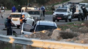 عناصر من الجيش والشرطة الإسرائيليين يقومون بتفتيش مركبة في أعقاب هجوم دام بالقرب من مستوطنة عوتنيئل، جنوبي مدينة الخليل بالضفة الغربية، 13 نوفمبر، 2015. (AFP/Hazem Bader)