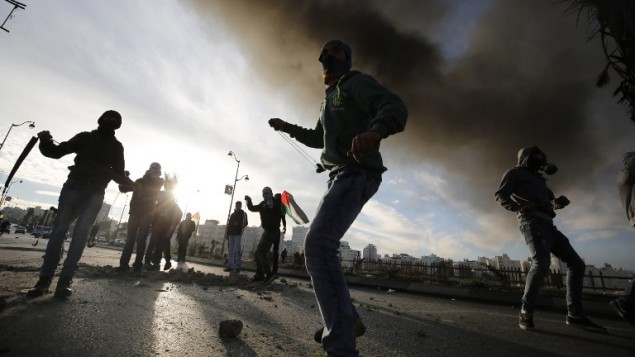 فلسطينيون يرشقون الحجارة باتجاه قوات الأمن الإسرائيلية خلال اشتباكات بالقرب من البيرة على ضواحي رام الله، 20 نوفمبر 2015 (AFP PHOTO/ABBAS MOMANI)