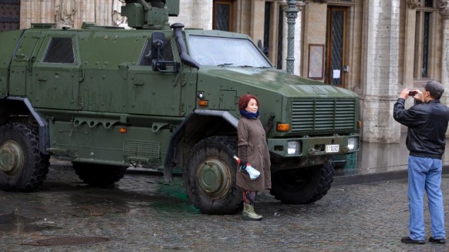 صورة تم إلتقاطها في 21 نوفمبر، 2015 يظهر فيها سياح يلتقطون صورا أمام مدرعة عسكرية بالقرب من غراند بلاس في وسط مدينة بروكسل.  (AFP PHOTO / BELGA / NICOLAS MAETERLINCK)