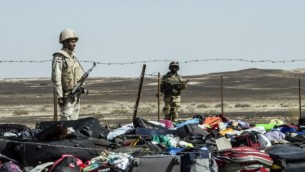 جنود مصريون يقفون بجانب أمتعة وحقائب مسافري طائرة A321 المنكوبة في موقع تحطم الطائرة في وادي الظلمات، وهي منطقة جبلية في شبه جزيرة سيناء، 1 نوفمبر، 2015. (AFP PHOTO / KHALED DESOUKI)