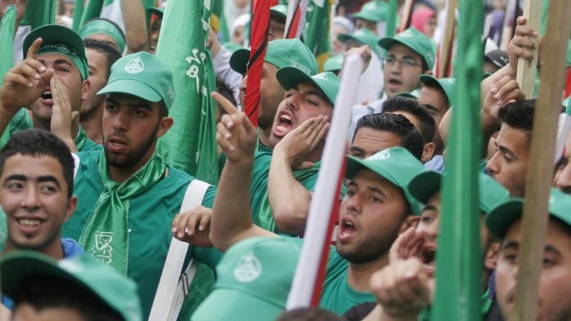 مناصرون فلسطينيون لحركة حماس يشاركون في مسيرة عشية إنتخابات مجلس الطلبة في جامعة بير زيت، في ضواحي مدينة رام الله، الثلاثاء، 6 مايو، 2014. (Issam Rimawi/Flash90)