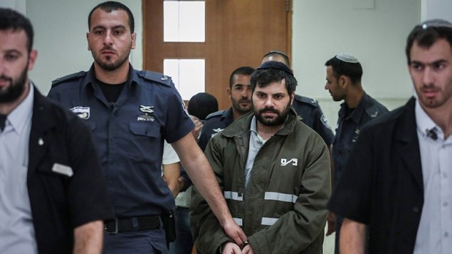 رجال الشرطة يرافقون يوسف بن دافيد، أحد المشتبه بهم اليهود في قتل المراهق محمد ابو خضير، في المحكمة المركزية في القدس، 8 يونيو 2015 (Hadas Parush/Flash90)