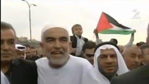رئيس الفرع الشمالي للحركة الإسلامية في إسرائيل رائد صلاح (في الوسط) وعضو الكنيست جمال زحالقة (من اليسار)خلال تظاهرة في 28 نوفمبر، 2015. (لقطة شاشة: القناة 2)