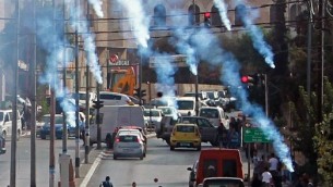 محتجون فلسطينيون يركضون للإحتماء من الغاز المسيل للدموع الذي تطلقة القوات الإسرائيلية خلال مواجهات في مدينة بيت لحم في الضفة الغربية، 2 أكتوبر، 2015. (Musa al Shaer/AFP)