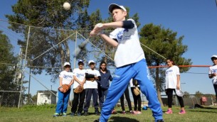 طفل يستعد لصرب الطابة ضمن برنامج "بيسبول للجميع"، برنامج تعايش إسرائيلي. (Courtesy Association of Baseball in Israel)