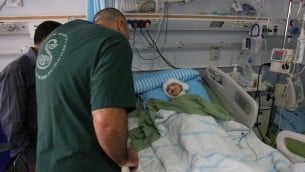 حسين دوابشة وطبيب بجانب سرير احمد دوابشة  في مركز شيبا الطبي في تال هشومير (Eric Cortellessa/Times of Israel)