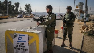 جنود إسرائيليون يقفون عند حاجز في مفرق غوش عتصيون، نقطة عبور رئيسية للضفة الغربية، 23 نوفمبر، 2015. (Gershon Elinson/FLASH90)