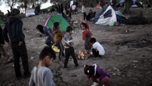 اطفال لاجئين ومهاجرين في حقل بالقرب من مخيم موريا في جزيرة ليزبوس اليونانية، 4 نوفمبر 2015 (ARIS MESSINIS / AFP)