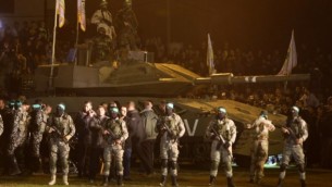 نطشاء فلسطينيون من الجناح العسكري لحركة حماس يقفون حول نموذج مقلد لدبابة إسرائيلية في 31 يناير، 2016 في مدينة غزة خلال تجمع للإشادة بالغزيين الذين قُتلوا في انهيار نفق. (AFP / MAHMUD HAMS)