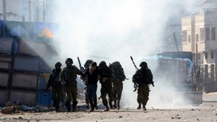 جنود إسرائيليون يعتقلون فلسطينيا خلال مواجهات في قباطيا، بالقرب من جنين في شمال الضفة الغربية، 4 فبراير، 2016. (Jaafar Ashtiyeh/AFP)
