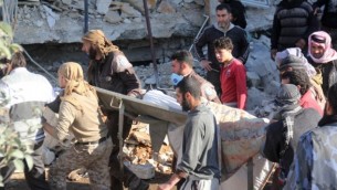 أشخاص يحملون نقالة وسط الحطام بعد تعرض مستشفى مدعوم من منظمة أطباء من دون حدود لغارات جوية يُشتبه بأنها روسية بالقرب من معرة النعمان، في محافظة إدلب الشمالية، 15 فبراير، 2016. (AFP / Omar haj kadour)