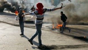 مراهقين فلسطينيين يرشقون قوات الامن الإسرائيلية بالحجارة خلال اشتباكات في مدينة الخليل في الضفة الغربية، 20 نوفمبر 2015 (AFP/Hazem Bader)