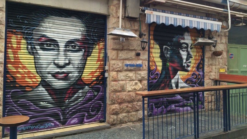 براخا زافيرا (من اليسار) وهداسا بادوخ كروغر من رسم سولومون سوزا، في سوق محانيه يهودا في القدس، 25 فبراير، 2016. (Renee Ghert-Zand/Times of Israel)