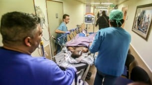 الطاقم الطبي يرافق منفذ هجوم إلى غرفة الطوارئ في مستشفى برزيلاي في إشكلون بعد قيامه بطعن رجل في مدينة أشكلون جنوبي إسرائيل، 27 فبراير، 2016. (Edi Israel/Flash90)