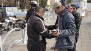 قوات الأمن الإسرائيلية تجري تفتيشا جسديا على عرب من مواطني إسرائيل بالقرب من محطة الحافلات المركزية في هرتسليا، في الوقت الذي تجري فيه عمليات بحث في المدينة التي تقع وسط إسرائيل بعد إعلان حالة تأهب خشية هجوم محتمل، 5 يناير، 2016،  تم نشر قوات الأمن في هرتسليا للتفتيش عن مركبة مشبوهة فرت من منطقة القدس. (Tomer Neuberg/Flash90)