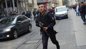 رجل شرطة تركي يركض في شارع إستقلال بمدينة إسطنبول في 19 مارس، 2016 (Bulent Kilic/AFP)