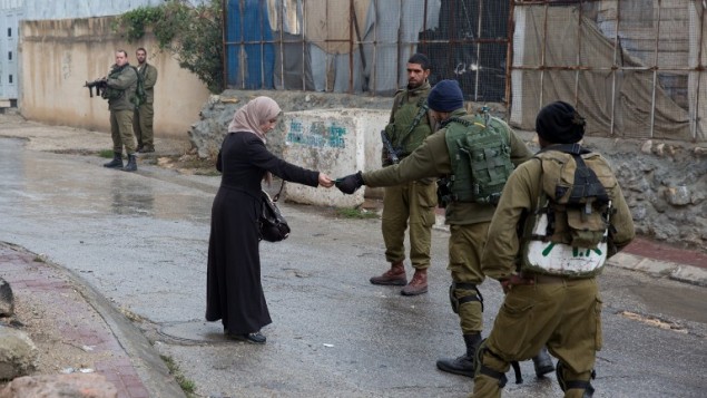 صورة توضيحية: جنود إسرائيليون يتحققون من هوية سيدة فلسطينية بالقرب من مستوطنة يهودية في الخليل، 29 أكتوبر، 2015. (AFP/Menahem Kahana) صورة توضيحية: جنود إسرائيليون يتحققون من هوية سيدة فلسطينية بالقرب من مستوطنة يهودية في الخليل، 29 أكتوبر، 2015. (AFP/Menahem Kahana)