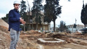 مدير أعمال الحفر، أليكس ويغمان، يقف إلى جانب مخمرة أثرية تم اكتشافها في قاعدة شنلر العسكرية السابقة في القدس. (سلطة الآثار الإسرائيلية)