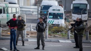 صورة توضيحية لعناصر أمن إسرائيليين يوقفون رجلا فلسطينيا عند مدخل مخيم شعفاط للاجئين في القدس الشرقية، 2 ديسمبر، 2015. (Hadas Parush/Flash90)