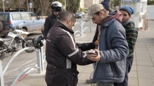 قوات امن اسرائيلية يفتشون عرب اسرائيليين بالقرب من محطة الحافلات المركزية في هرتسليا، 5 يناير 2016 (Tomer Neuberg/Flash90)