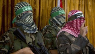 أبو عبيدة (من اليمين)، المتحدث الرسمي للجناح العسكري لحركة حماس، كتائب عز الدين القسام، في مؤتمر صحفي في 3 يوليو، 2014، في مدينة غزة. (AFP/Mohammed Abed)