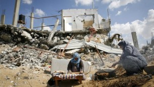 أمرأة فلسطينية تخبز الخبز وسط أنقاض منزلها المدمر في مدينة خان يونس، جنوبي قطاع غزة، 21 سبتمبر، 2014. (Abed Rahim Khatib/Flash90)